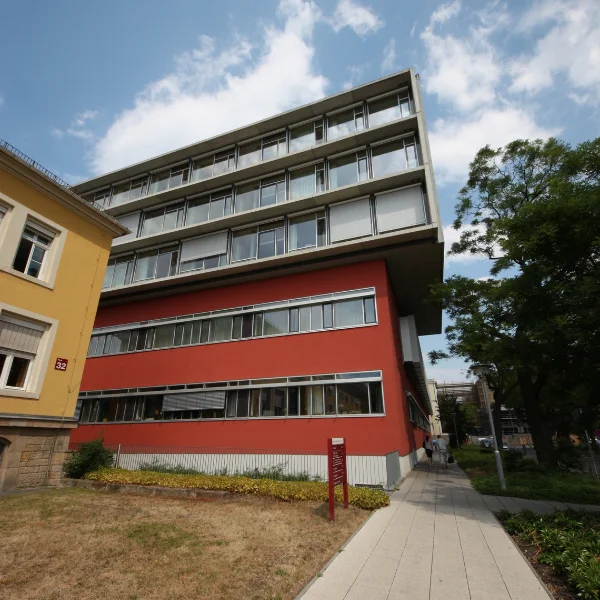 Bild eines Gebäudes mit einem roten Unterbau und einem etwas überstehenden silbrigen Bau oben